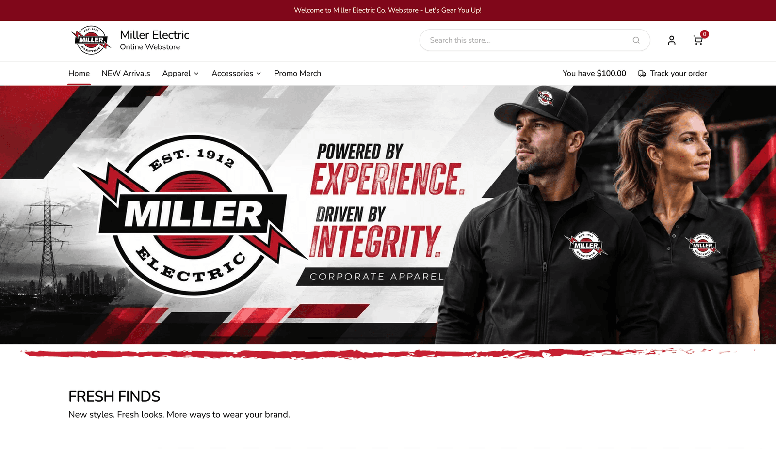 The Miller Electric company webstore: a corporate apparel banner with staff in logo jackets and polos, category navigation and a $100.00 points balance